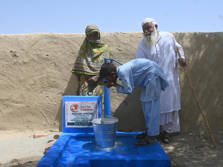 En pojke dricker från en ny handpump i Punjab, Pakistan
